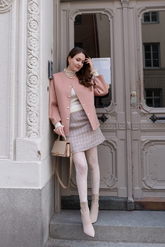 a lady in a white knit top, a pink wool jacket and a pink tweed A-line skirt